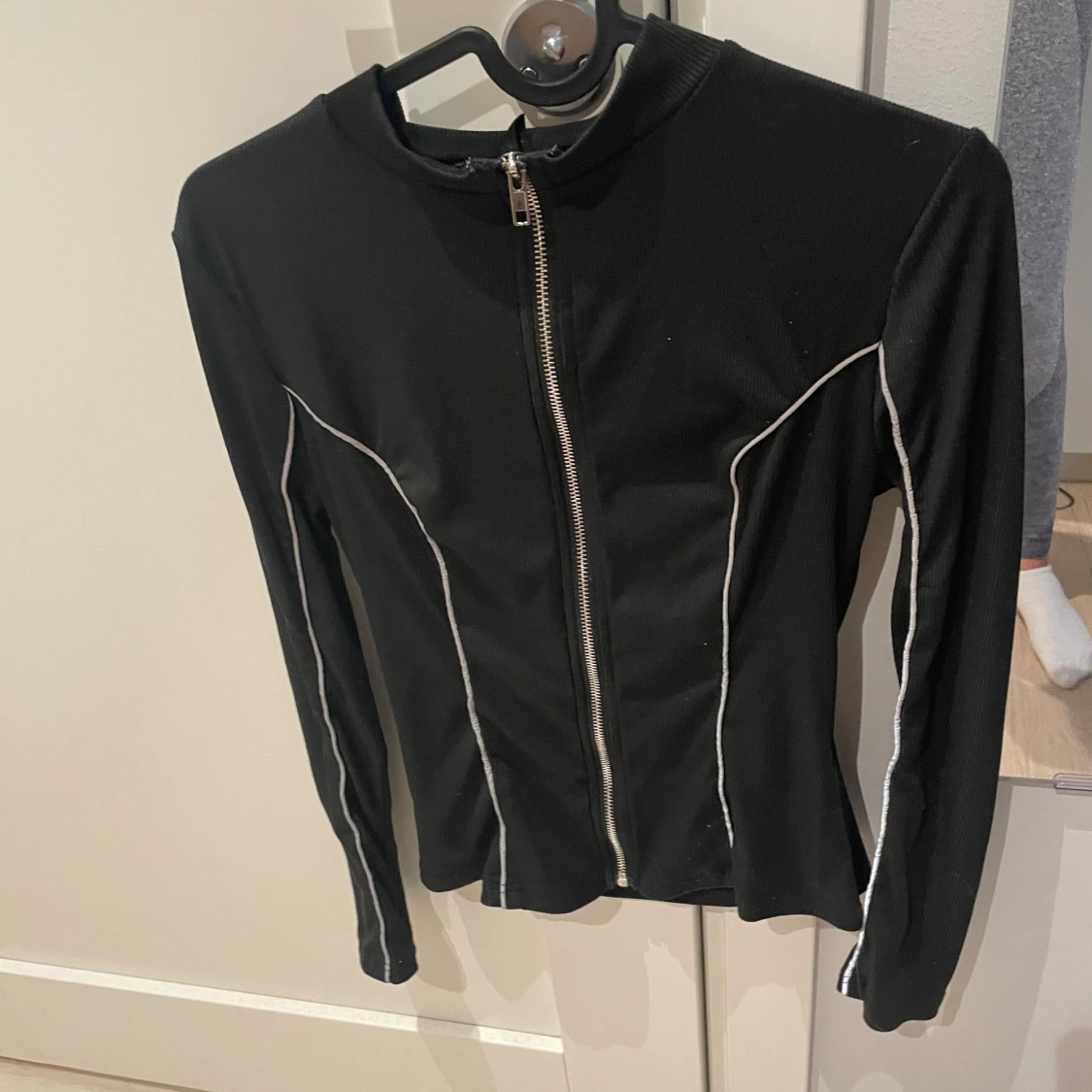 Svart ziptröja med vita sömmar