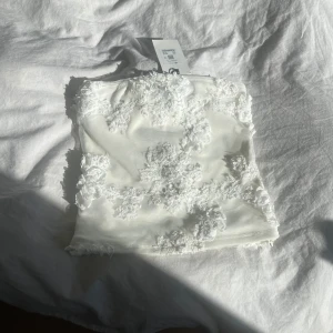 Vit tubtopp - Jättesöt vit tubtopp med vita detaljer ifrån Bikbok, helt oanvänd med prislapp kvar, på tredje bild syns en liten liten sminkfläck på insidan (går bort i tvätt), tyvärr för liten för mig, nypris låg på 300kr!!💗💗