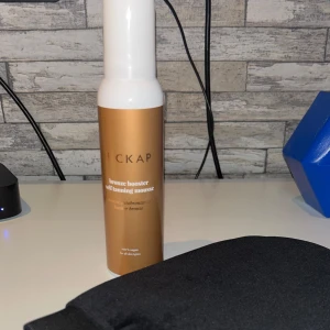 Hickap brun utan sol med appliceringsvante - Säljer en helt ny Hickap Bronze Booster Self Tanning Mousse i snygg bronsfärgad flaska med vit pump. Medföljer en svart appliceringsvante i mjukt material för jämn applicering. Moussen är vegansk och passar alla hudtyper, perfekt för att få en solkysst glow.