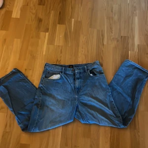 Blå relaxed/loose fit jeans från Lee - Säljer ett par klassiska blå jeans från Lee med loose fit och rak passform. Säljer de då jag inte passar i de riktigt och har vuxit ur de. 