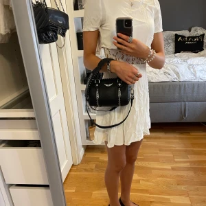 Vit spetsklänning  - Supersöt vit kort klänning med snygg spetsdetalj i midjan. Storlek XS. 