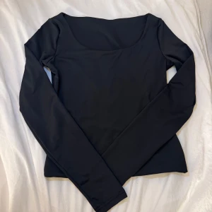 Svart långärmad topp - En stilren svart långärmad topp med rundad halsringning.