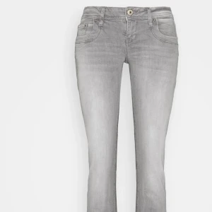 Grå bootcut jeans med fem fickor - Snygga grå jeans med bootcut passform och klassisk femficksdesign. Jeansen är ljusgrå. Tillverkade i mjukt denimtyg med knapp och dragkedja framtill. Aldrig använda.