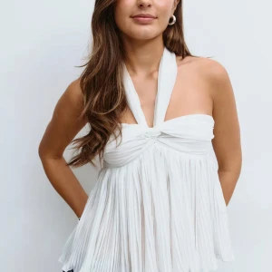 Vit plisserad halterneck topp - Supersnygg vit halterneck topp med plisserat tyg och knyt runt nacken. Toppen har en flowy och luftig passform med twistad detalj framtill. Perfekt till nästa sommar. Har aldrig använt men prislappen är borttagen men är tyvärr förliten på mig. 