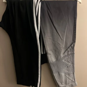 Två par leggings, svart och grå - Säljer två par leggings, ett par helsvarta adidas med vita ränder längs sidorna och ett par grå från Victora’s Secret (PINKkr med snyggt mönster på benen. Perfekta för träning. Båda är stretchiga och bekväma.