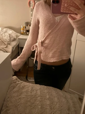 Ljusrosa omlottkofta med knytband - Supersöt ljusrosa omlottkofta med knytband i midjan och långa ärmar. Från Gina Tricot 