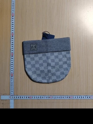 Grå rutmönstrad mössa från KANGOL - Snygg grå mössa från KANGOL med vikbar kant och diskret rutmönster i olika grå nyanser. Klassisk patch med logga framtill. Perfekt accessoar för dig som vill ha en stilren och modern look till hösten och vintern.