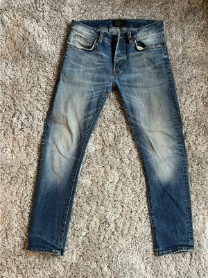 D.Premium Jeans 32/32 - Ett par D.Premium Jeans som Lavato har behabdlat med unika slitningar och tvätt på framsidan och baksidan