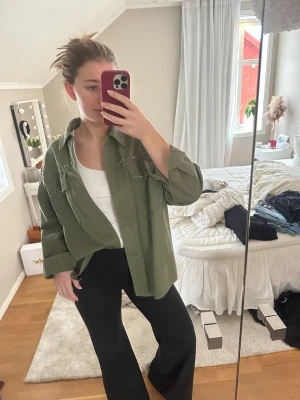 Olivgrön jeansjacka med stenar/pärlor - Säljer en grön jeansjacka från Zara med pärlor/stenar. Använt fåtal gånger går att knäppa ihop armarna.💗