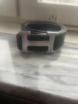 Svart läderbälte med H-spänne - Svart H.ermes bälte litet slitet men de syns inte så mycket.