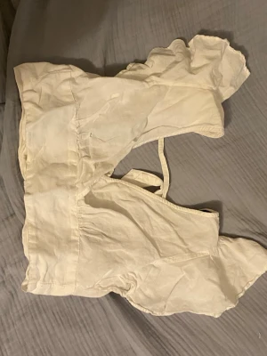 Vit topp med volang och knyt - Säljer en vit topp med volangdetaljer och knyt i ryggen. skriv om ni undrar om något 💕(läs min profil)