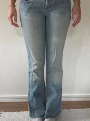 Ljusblå bootcut jeans - Säljer dessa as snygga vintage jeans!! Relativt low rise, skriv om ni vill ha mått. Finns några små defekter vid grenen, men ingenting som syns eller som man tänker på! Är dessutom lite slitna längst ner på byxorna, men jag tycker det bidrar lite till ”vintage looken”❣️❣️ Står tyvärr ingen storlek, men jag brukar ha W26 och är lite stora på mig så skulle säga att de är W27/28. 