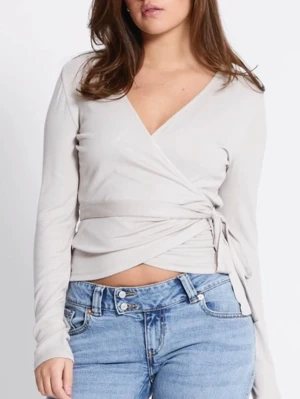 Beige omlottopp med knytband - Trendig beige omlottopp från Lager 157 med långa ärmar och knytband i midjan. Har aldrig använts och har prislapp kvar. (Färgen ser annorlunda ut pga belysning) Nypris: 150kr