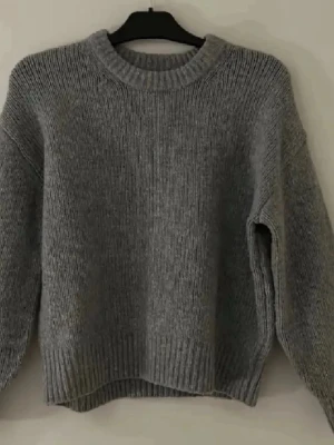 Grå stickad tröja med rund hals - Så himla snygg och passar bokstavligen till allt! Den håller varm och är super för vintern. Tröjan har bra passform och fin färg. Den har dock små små rosa fläckar vid halsringningen som ej är super synlig kan skicka bilder!❤️❤️