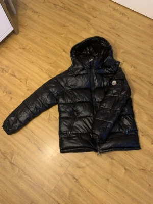 Moncler Maya (Svart) - Svart moncler maya jag har använt den i halva vintern, jag vill sälja den pågrund av att jag vill köpa en canda gose 