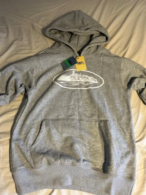 Grå Corteiz hoodie - Grå Corteiz hoodie som aldrig har varit använd, vilket betyder att den är i perfekt skick. Anledningen till att jag säljer är att den inte passar. 