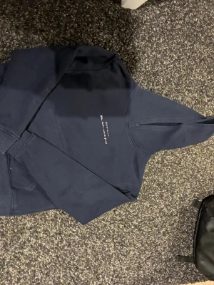 Mörkblå Bitte succé hoodie  - Snygg mörkblå hoodie med huva och broderad text på bröstet. Klassisk känguruficka framtill och ribbade muddar vid ärmar och midja. Perfekt för en avslappnad och trendig look. Materialet känns mjukt och bekvämt, troligen bomull eller bomullsblandning.