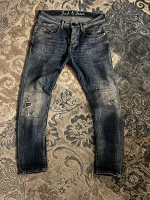 Blå slitna jeans från Jack & Jones - Snygga blå jeans från Jack & Jones med slitningar och trasiga detaljer på benen. Jeansen har klassisk femficksmodell, normal passform och är tillverkade i denim. Perfekta för en avslappnad och trendig look.