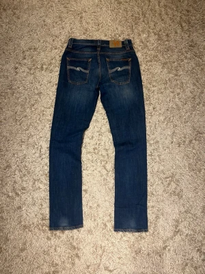 Nudie jeans modell grim Tim slim fit herr  w30 - Nudie jeans modell grim tim. Slim fit med en riktigt fet fade och snygga whiskers. Mycket bra skick, inga märkvärdiga defekter. Storlek w30 L 32. Postas samma dag som köp eller dagen därpå🙌💯