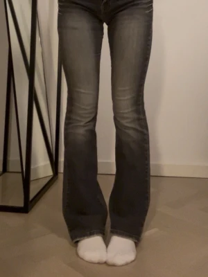 Grå lågmidjade bootcut jeans - Grå Levi’s vintage bootcut-jeans köpta på second hand! Klassisk passform med snygg bootcut som sitter fint över höfterna och faller bra över skorna. Passar mig som brukar ha storlek S och är runt 1,66 cm lång.🤍 Liiite slitna vid hälarna (bild längst bak)