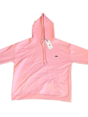 Rosa Lacoste hoodie - Säljer denna feta Lacoste hoodien i färgen rosa. Skicket är 10/10 och tröjan är i Storlek M. Perfekt nu inför våren/sommaren. Var inte rädd att ställa mig några frågor om hoodien! Mch KC Closet 😁