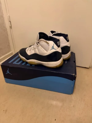 Air Jordan 11 Retro Win Like '82 2017 - Skick: Mycket fint begagnat Typ: äkta Storlek: EU 47,5 / US 13 Inkluderar: Orginal Kartong (se bild)  Säljer ett par äkta Air Jordan 11 Retro i navy/blå och vit färg. Skorna är använda men i mycket bra skick. Väldigt hög kvalitet då de är originala.  ✔ Jordan 11 ✔ Klassisk och eftertraktad design ✔ Bekväma & stilrena ✔ Sulor i fint skick  📏 Storlek: EU: 47,5 US: 13  Pris: 999 :- Möts upp / skickas: 