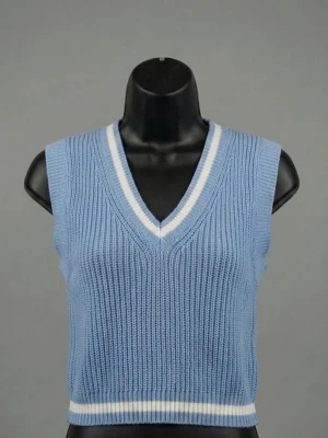 Blå stickad väst med v-ringning - Säljer en ljusblå stickad väst med v-ringning och vita ränder vid halsen och nederkanten. Perfekt att bära över en skjorta eller t-shirt för en trendig lager-på-lager-look. Västen är ribbstickad och har en avslappnad passform.