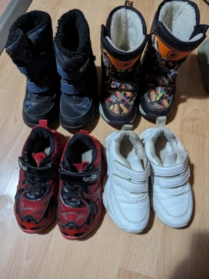 Färgglada vinterstövlar med mönster - Säljer ett par vinterstövlar med färgglatt mönster i orange, blått och gult. Stövlarna har svart bas, snörning framtill och varm fodring. Perfekta för kalla dagar och lek i snön.