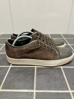 Lanvin Sneakers - Lanvin DBB1 Sneakers i brun färg. Skorna är i storlek 7 vilket motsvarar ungefär EU 42. Endast skorna medföljer. Skick 9/10. Inga defekter, endast små tecken av användning på sulan. Priset är ej hugget i sten