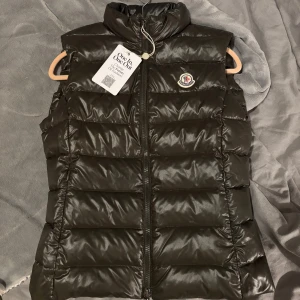 Dunväst från Moncler - Snygg mörkgrön dunväst från Moncler, stl 1. Super cool färg och sälj på grund av för liten i storlek. Köpt på Vestiaire Collective och genomgått äkthetskontroll, etikett finns kvar från kontroll.
