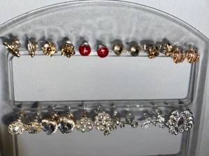 23 par örhängen i olika färger och former - Säljer 23 par örhängen i olika stilar, söta och glamiga. Använda men i fint skick. Perfekt för någon som vill uppdatera sin smyckessamling!