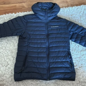 Mörkblå dunjacka Peak Performance - Mörkblå lättvikts dunjacka från peak performance. Använd fåtal gånger inga synliga tecken på slitage, liten fläck på insidan av jackans ficka men inget som syns eller stör! 
