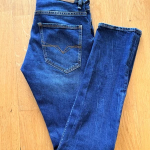GUESS Slim Fit - Snygga blå skinny jeans från Guess med låg midja. Klassisk femficksmodell med tydliga sömmar och logga på bakfickan. Jeansen är i stretchigt denimtyg som sitter tight och har en modern look.