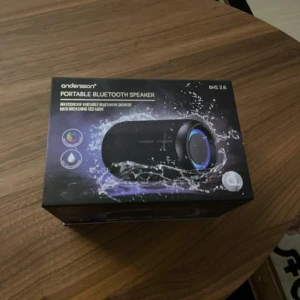 Andersson BHS 2.6 Portable Bluetooth Speaker - Vattentät portabel Bluetooth-högtalare med andnings LED-ljus. Kompakt design, perfekt för utomhusbruk. Levereras i originalförpackning och är i nyskick utan synligt slitage eller defekter. Enkel att ta med tack vare praktisk rem.