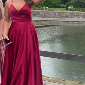 Balklänning - Röd balklänning som endast använts en gång därav är i bra skick. Öppen i ryggen med band som är justerbara. Nypris 3500kr