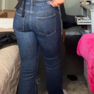 Mörkblå bootcut jeans med hög midja - Säljer ett par mörkblå jeans med bootcut passform och hög midja. Jeansen har klassiska fem fickor, bälteshällor och är tillverkade i ett stretchigt denim-material som sitter snyggt och bekvämt. Perfekta för dig som gillar en tidlös och cool look.