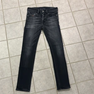 Diesel jeans - Svarta skinny jeans från Diesel, modell Sleenker med stretch. Snyggt slitna detaljer och klassisk femficksdesign. Passformen är tight och benen är smala hela vägen ner. De är små i storleken.