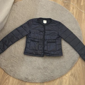 Marinblå jacka ifrån ginatricot - Den är tunn så perfekt till sommaren vår eller början på hösten . Stolen 170