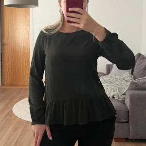 Grön blus  - Grön blus storlek 34. Knappar fram och på ärmarna 