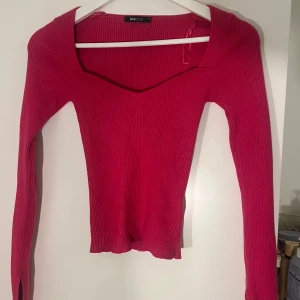 Ribbad rosa topp från Gina Tricot - Säljer en ribbad rosa topp från Gina Tricot med lång ärm och snygg v-ringad halsringning. 