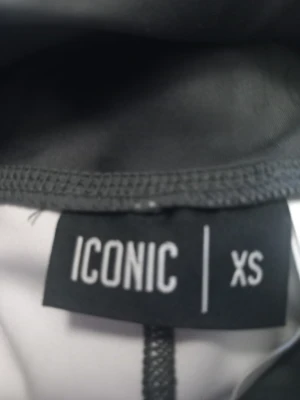 Svarta leggings från Iconic XS - Säljer ett par svarta leggings från Iconic i storlek XS. De har ett diskret mönster och snörning i midjan för extra komfort. Materialet är stretchigt och passar perfekt för träning eller chill. Snygg och tight passform som framhäver benen.