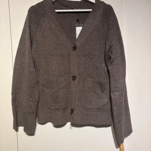 Brun stickad kofta med knappar - Mysig brun stickad kofta från lager157 med v-ringning. Prislappen kvar