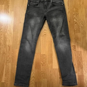 Grå jeans från J.Lindeberg 32/32 - Snygga grå jeans från J.Lindeberg i storlek 32/32. Modellen har klassisk femficksdesign, raka ben och subtila slitningar för en cool look. Jeansen är tillverkade i mjukt bomullsmaterial med stretch för extra komfort.