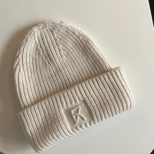 Mössa - Beige/off white mössa med detalj fram (bild 1). Färgen syns bäst på bild 2. Använd fåtal gånger och är i bra skick. Köparen betalar frakten! 