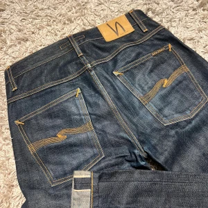 Dry Selvedge nudie jeans modell grim trim i slim striaght passform - Dry Selvedge nudie jeans modell grim trim i slim striaght passform. Nytt skick inga defekter, riktigt najs material. Storlekslappen är tyvärr klippt men sitter som w30 passar 31 också, 100% organic cotton. Postas antigen samma dag som köp eller dagen därpå, gratis frakt!🙌💯