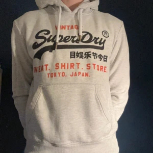 Superdry Hoodie M - Riktig snygg hoodie från Superdry, hoodien är i storlek M och passar mig perfekt som är 178. Den är i fint skick och har inte större defekter förutom texten men det märks inte jättemycket vid användning.