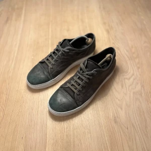 Lanvin skor - Säljer ett par snygga grå Lanvins. Skick: 7/10. Små defekter, se bild. Storlek : 43 men passar som 44.   Perfekt för dig som gillar stilrena och exklusiva sneakers med coola materialdetaljer.