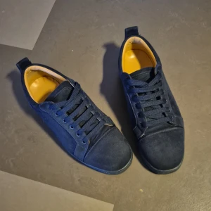 Mörkblå mockasneakers med röd sula - Snygga mörkblå sneakers i mocka med klassisk snörning och rund tå. Skorna har en unik röd sula med grafiskt mönster undertill och kontrasterande gul insida. Perfekta för dig som vill ha en stilren men ändå unik look. Säljs för 699 kr men kan gå ned vid snabb affär. Tyvärr följer bara skorna med för jag har råkat slänga box o annat