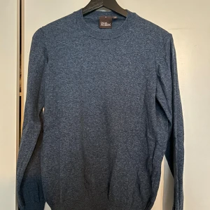 Mörkblå stickad tröja Oscar Jacobson - Snygg mörkblå stickad tröja från Oscar Jacobson. Klassisk rund halsringning och långa ärmar. Perfekt för lager-på-lager och passar till både jeans och chinos. Mjuk och skön känsla tack vare ullmaterialet. Storlek s men sitter nog mer åt xs hållet.