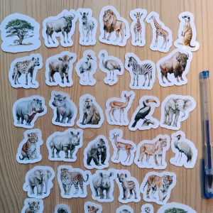 36 st klistermärken  safari djuren - 36st. Bilden visar klistermärken med motiv av afrikanska djur och natur, såsom lejon, elefant, zebra, giraff och träd. Ingen elektronikprodukt syns på bilden.